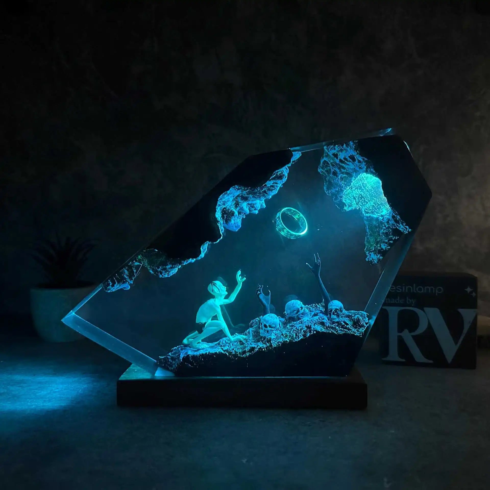 Alternate view of gaunt figure reaching toward a ring in ember-lit resin showing the material edge and internal lighting