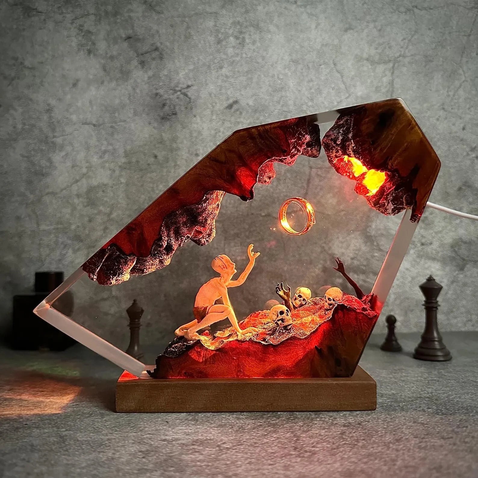 The Hollow Claim, gaunt figure reaching toward a ring in ember-lit resin, illuminated in ember red, violet, and blue light
